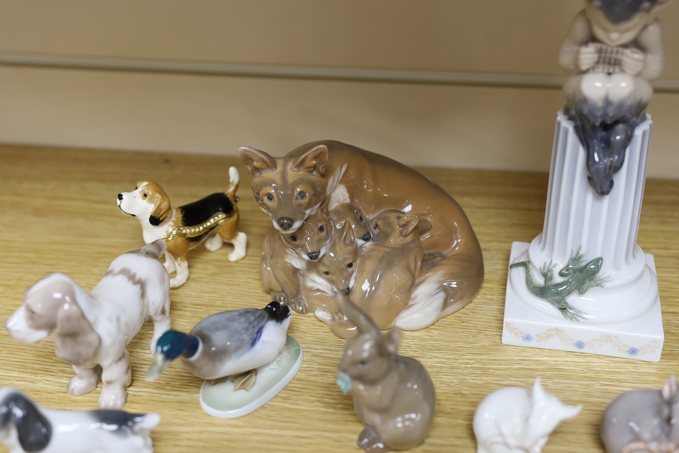 Sixteen various Royal Copenhagen porcelain birds and animals, including a faun playing pipes, a fox group and a metal foxhound, faun 21 cms high